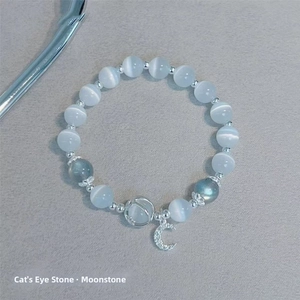 Detail of cat eye and moonstone beaded bracelet with a silver crescent moon pendant