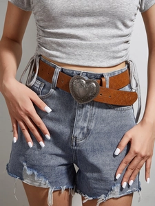 Detail of vintage brown belt with engraved heart-shaped buckle and paisley textures