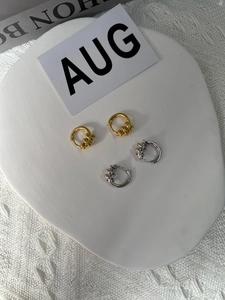 Macro view of twisted S925 sterling silver hoop earrings in gold and silver finishes