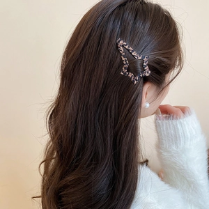 Dettaglio macro di un fermaglio per capelli a stella leopardato indossato sui capelli