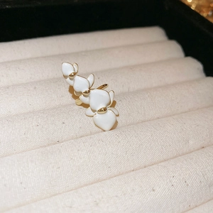 Detailed close-up of white orchid flower ear cuff with gold plating in a jewelry box