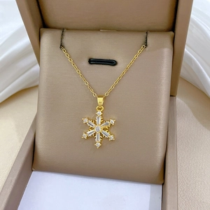 Detailansicht eines goldenen Schneeflocken-Anhängers mit Zirkonia-Steinen in einer Box