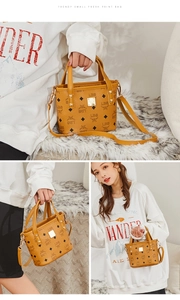 Close-up of trendy digital print bucket bag with gold rivets and detachable strap