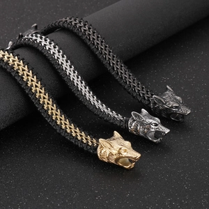 Detailed view of woven leather bracelets with silver and gold wolf head metal clasps