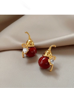 Detail of gold-plated gourd earrings with red beads and heart-shaped zircon on satin