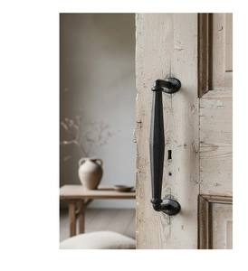 Detailed close-up of vintage cast iron door handle with black hammered texture finish