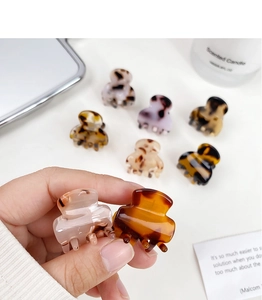 Close-up of mini tortoise shell acetate hair claws on a clean white background