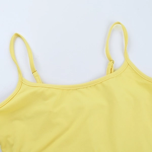 Détail du décolleté d'un caraco en maille jaune avec fines bretelles et texture douce