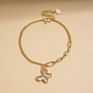 Close-up of gold butterfly pendant with honeycomb texture and adjustable heart clasp