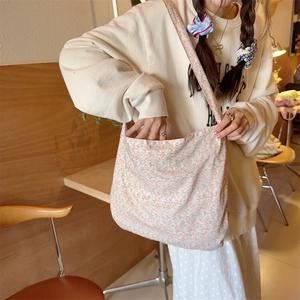 Close-up of floral canvas bag with green and pink patterns in a cafe setting