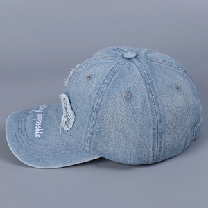 Dettaglio del berretto in denim con ricamo Nothing is impossible sulla visiera curva
