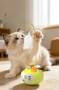 Interactive tumbler cat toy with rotating ball and white feathers on a wooden floor