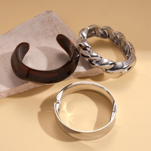 Minimalist geometric bangles set featuring tortoise resin and polished silver metal bracelets