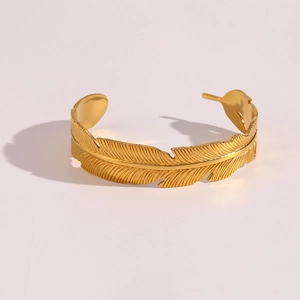 Macro detail of the elegant 18K gold leaf textured feather open bangle bracelet