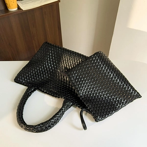 Large black hand-woven tote bag with matching zipper pouch and textured finish