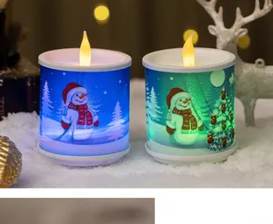 Close-up of LED Christmas candles with snowman and tree prints in a snowy setting