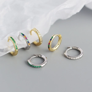 Close-up of geometric S925 silver hoop earrings with colorful inlaid crystals and gemstones