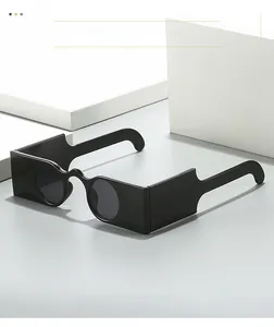 Detail shot of punk style square frame sunglasses with round lenses on white stone block