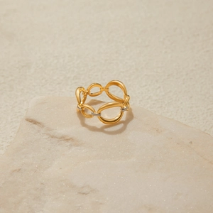 Détail d'une bague chaîne creuse bicolore en or 18K et argent sur socle en pierre