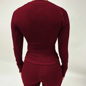 Détail du tissu en maille côtelée bordeaux et des coutures de l'ensemble de sport moulant