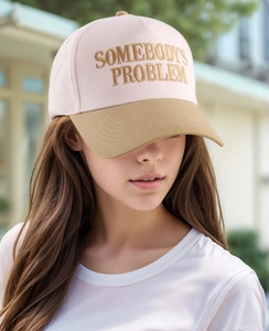 Detail of SOMEBODY'S PROBLEM embroidery on two-tone cotton baseball cap with khaki brim