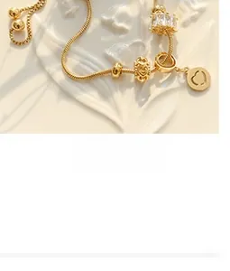 Close-up of 18K gold-plated snake chain bracelet with crystal heart charm on ceramic