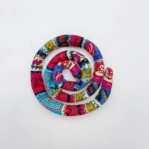 Detailed macro view of a colorful ethnic spiral hair tie with vibrant fabric patterns