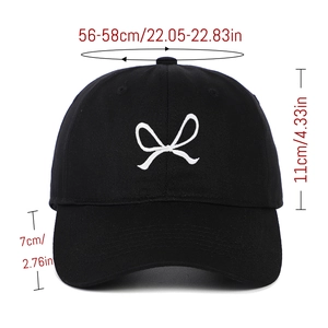 Macro view of white bow embroidery on black cotton baseball cap with size specs
