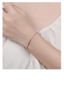 Close-up of gold chain bracelet with white cubic zirconia stones worn on a model wrist