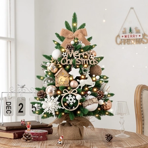 Mini tabletop Christmas tree with LED lights and festive ornaments on wooden base