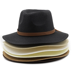 Close-up of stacked summer straw Fedora hats in black, beige, white, and brown colors