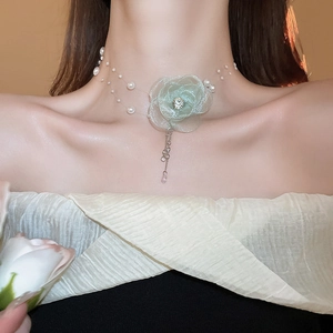 Detail of light green fabric flower choker with pearls and crystal center on model