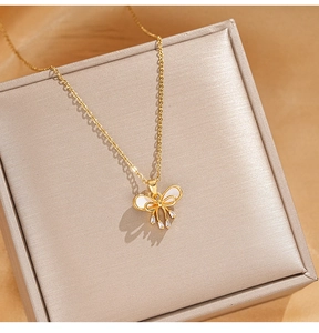 Détail du collier à nœud doré avec incrustation blanche et pierres de zircone