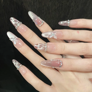 Sparkling pink cat eye press-on nails with silver butterfly rhinestones and diamond chains
