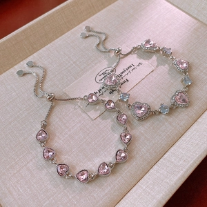 Close-up of pink heart zircon adjustable bracelets on a beige jewelry tray