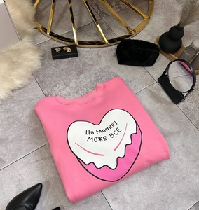 Gros plan du sweat rose oversize à imprimé cœur montrant la texture et les détails du motif