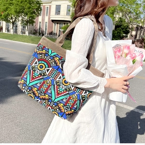 Ethnic style geometric canvas tote bag carried by a model in a casual street setting