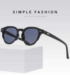 Detail view of matte black round frames with silver metallic accents and dark grey lenses