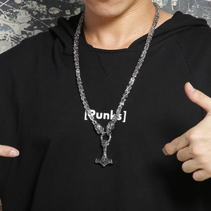 Detailed close-up of a Viking Mjölnir pendant with wolf heads on a Byzantine chain