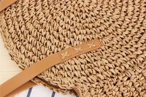 Close-up of woven paper rope texture and brown leather strap with decorative cross stitching