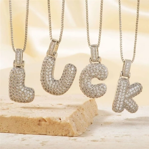 Bubble initial pendant LUCK necklace with cubic zirconia on premium satin backdrop