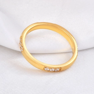 18K gold plated titanium steel ring with twelve inlaid stones on a soft white fabric