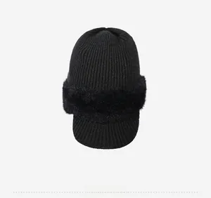 Top view of black knitted winter hat with faux fur trim and short brim detail