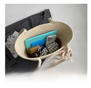 Close-up of the large interior capacity of this beige woven tote bag with daily items