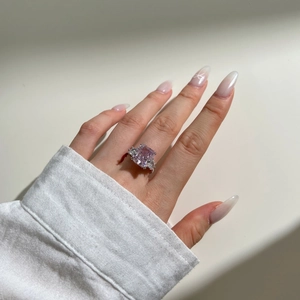 Macro shot of silver ring featuring pink square cut gemstone on model finger