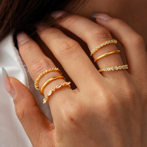 Detail of 18K gold plated ring set with zircon stones on model's hand close-up view