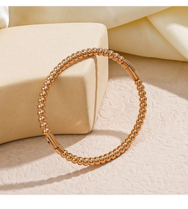 Detail of rose gold beaded bracelet with smooth cylinder clasps on beige display stand