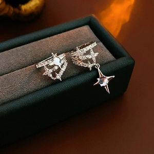 Macro shot of silver star ear clips with zircon and moonstone in a gray velvet jewelry box