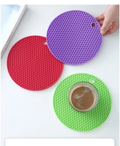 Detail of round honeycomb silicone coasters in red, purple and green with hanging hole