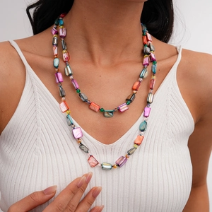 Detail of colorful layered shell beaded necklace featuring rectangular multi-color resin tiles